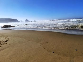 Scenic view of beach against clear sky