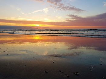 Scenic view of beach against sky during sunset