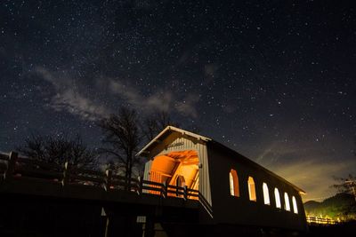 Low angle view of covered bridge against sky at night