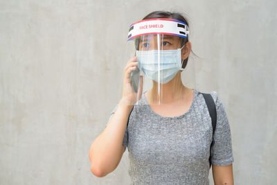 Portrait of woman standing against wall