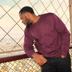 Man looking away while standing on railing