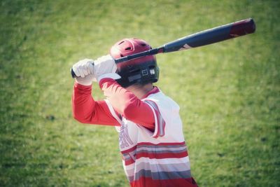 Midsection of boy holding umbrella on field