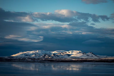 Mountains alongside a lake in iceland with moody clouds