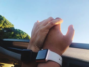 Close-up of hand holding car against sky