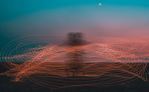 Digital composite image of light trails against sky at night