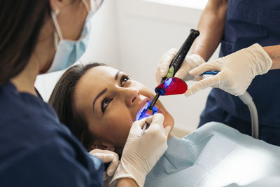 Female dentists operating patient in hospital