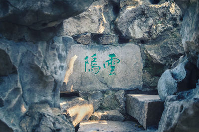 Text on rock against stone wall