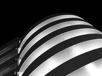 Low angle view of illuminated building against black background