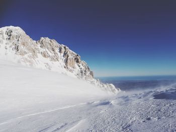 Scenic view of snow mountains against clear blue sky