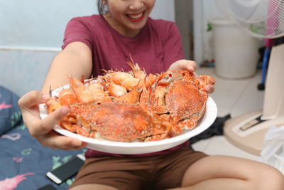 Portrait of smiling woman holding seafood