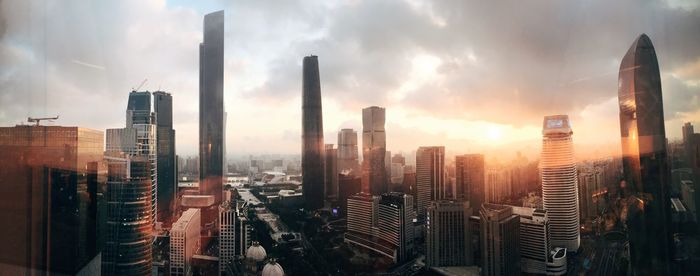 Skyscrapers against cloudy sky