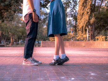 Low section of man and woman walking on footpath