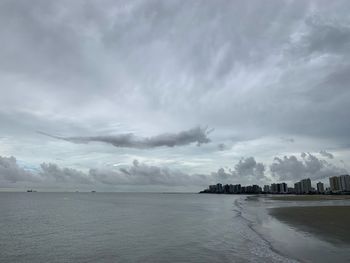 Scenic view of sea by buildings against sky