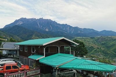 Houses by mountains against sky