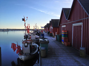 Boats moored at harbor by buildings against sky in city