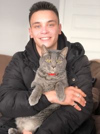 Portrait of smiling young woman with cat