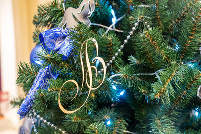 Close up of christmas tree decoration with baubles and letter b. festive greeting card 