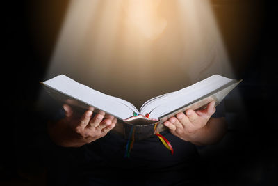 Midsection of woman reading book