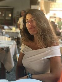 Portrait of woman looking away while sitting outdoors