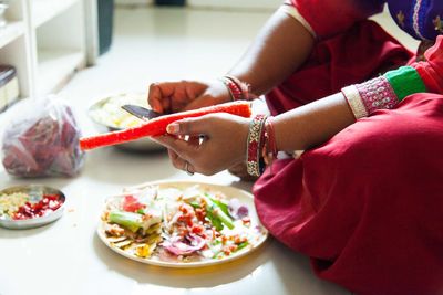 Low section of woman holding carrot