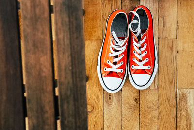 High angle view of orange shoes on hardwood floor