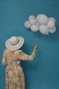 Cloudy day. concept with woman and white baloons against blue sky
