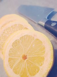Close-up of lemon slices by knife on table