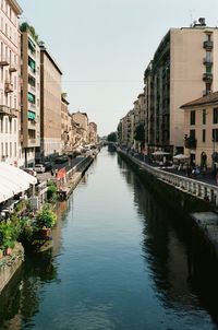 Canal amidst buildings in city against sky