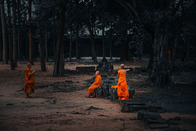 Rear view of people walking in forest