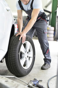 Car mechanic in a workshop changing car tyre