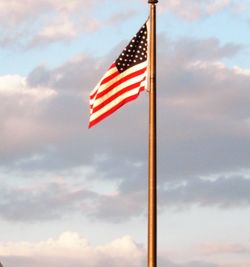 Low angle view of american flag against sky