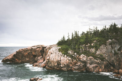 Rocks by sea against sky