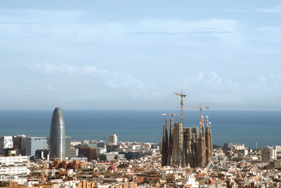 Modern buildings by sea against sky