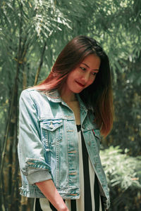 Beautiful woman standing against plants in park