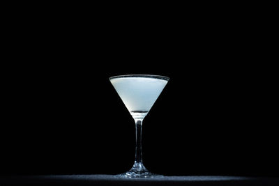 A glass of cocktail on a black background