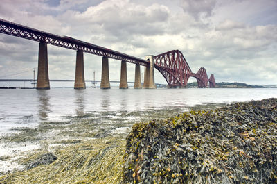 View of bridge over river against cloudy sky