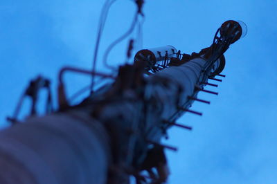 Low angle view of machine against blue sky