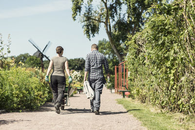 Rear view of couple walking at community garden