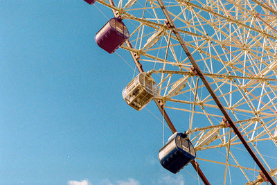 Low angle view of ferris wheel against blue sky