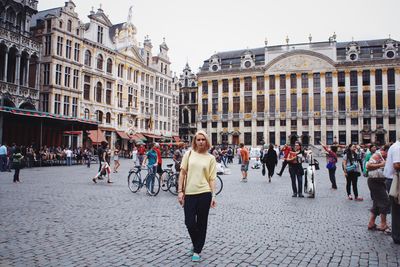 Portrait of woman standing on town square against historic buildings