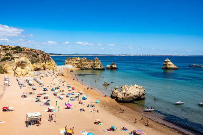 High angle view of people on beach against blue sky