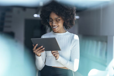 Smiling businesswoman using tablet pc at office