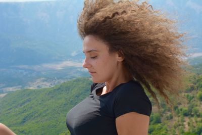 Young woman with curly hair on mountain