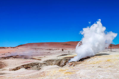 Scenic view of smoke on land against sky