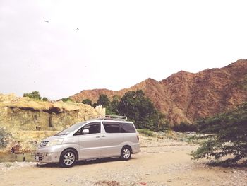 Car on mountain road against clear sky