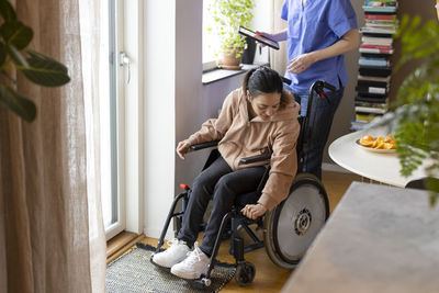 Woman with paraplegia adjusting wheelchair at home