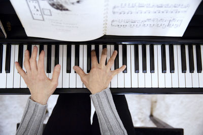 Overhead view of senior woman playing piano at home