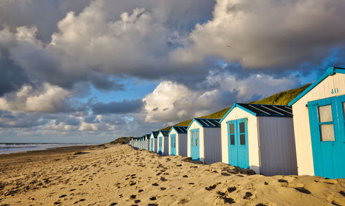 Beach huts by sea against sky