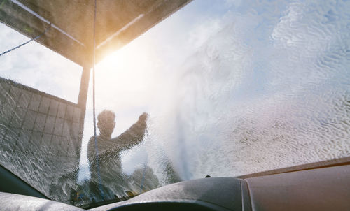 Man washing car seen through windshield