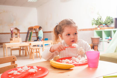 Girl eating meal at preschool